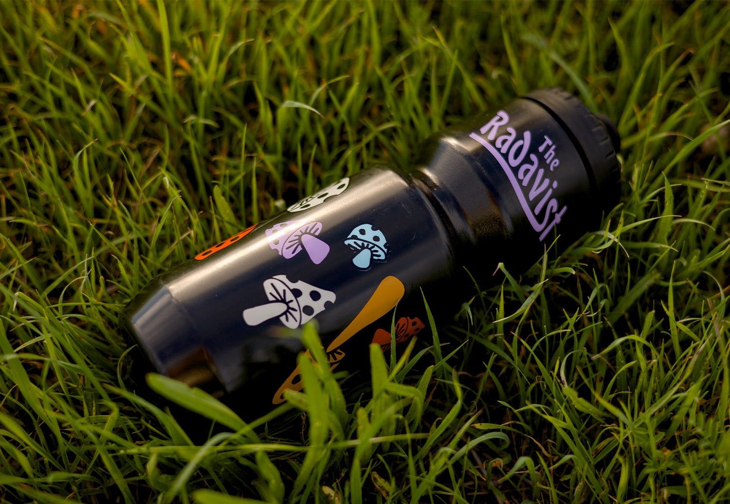 Purist custom water bottle placed in the grass