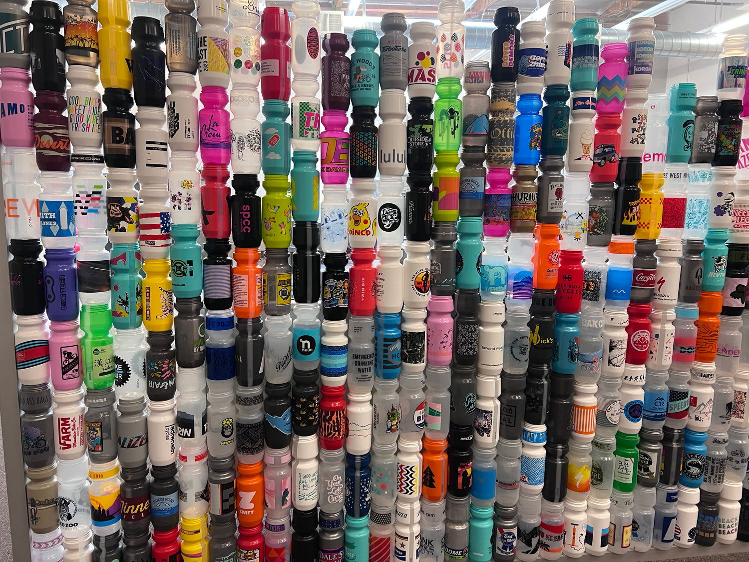 Collection of various specialized custom bottles with colorful labels arranged in a pattern.